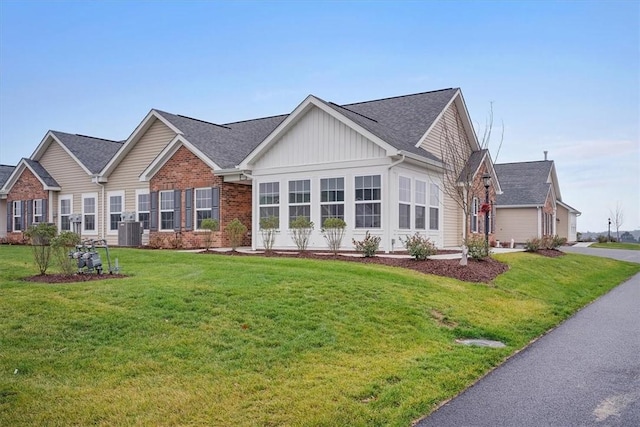 view of front of property with a front lawn and central air condition unit