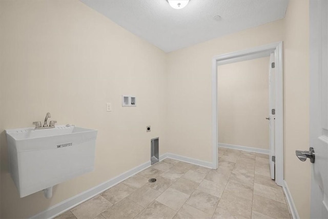 laundry area with electric dryer hookup, sink, washer hookup, and a textured ceiling