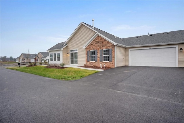 ranch-style house featuring a garage and a front lawn