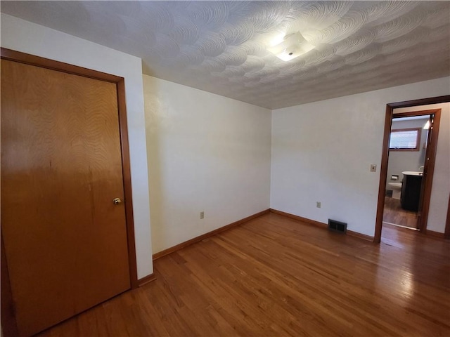 unfurnished bedroom with hardwood / wood-style floors and a closet