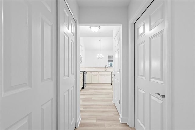 1261 Sandy Ridge Dr, Buffalo Twp, PA 16055 - hallway with sink, a chandelier, and light wood-type flooring