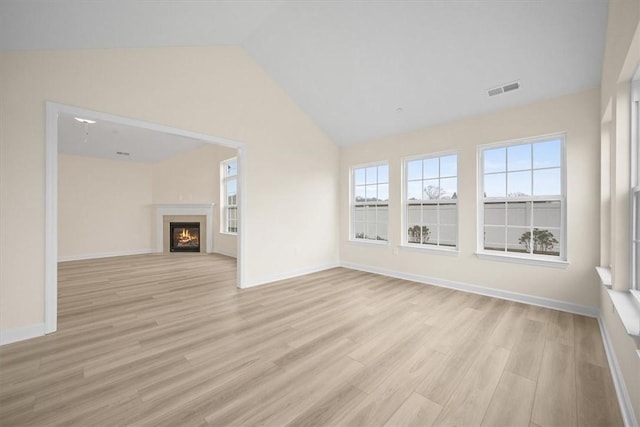 unfurnished living room with lofted ceiling and light hardwood / wood-style floors