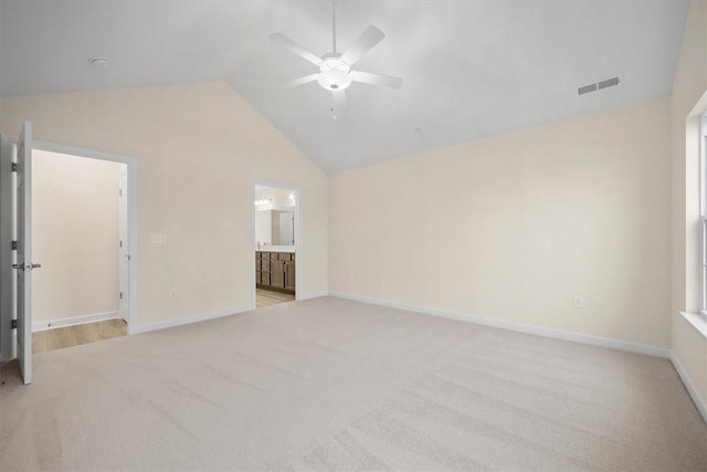 spare room with ceiling fan, lofted ceiling, and light carpet