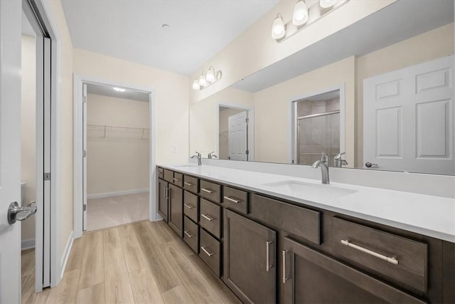 bathroom featuring hardwood / wood-style flooring, vanity, and walk in shower