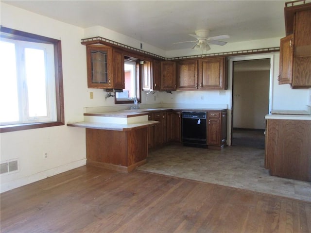 kitchen with sink, ceiling fan, dishwasher, dark hardwood / wood-style floors, and kitchen peninsula