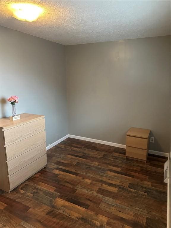 unfurnished bedroom featuring dark hardwood / wood-style floors and a textured ceiling