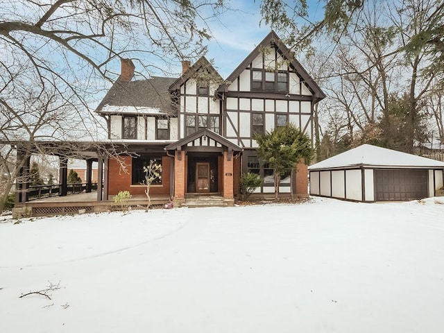 view of front of home featuring a porch, a garage, and an outdoor structure