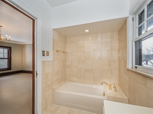 bathroom featuring a chandelier, tile patterned floors, a bathtub, and tile walls