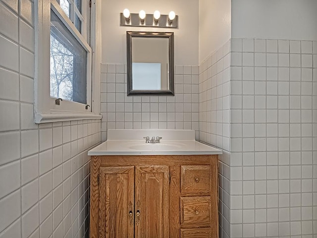 bathroom with vanity and tile walls