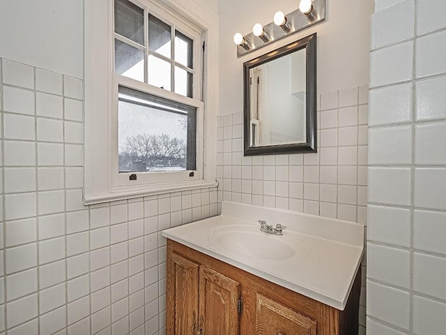 bathroom with vanity, a wealth of natural light, and tile walls