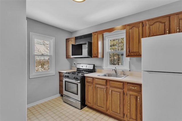 kitchen with white fridge, sink, and stainless steel range with gas cooktop