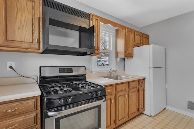 kitchen featuring sink, gas stove, and white refrigerator