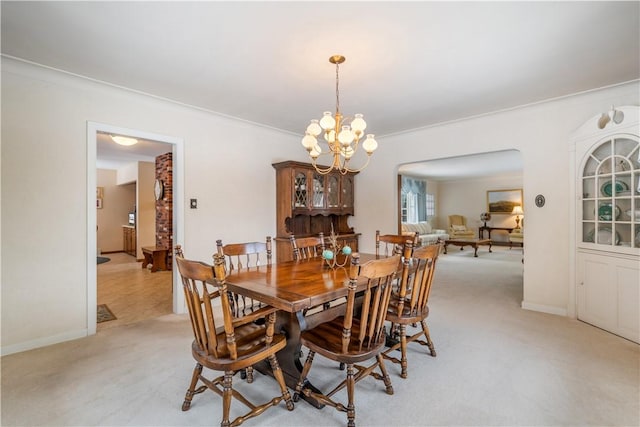 carpeted dining area with ornamental molding and a notable chandelier