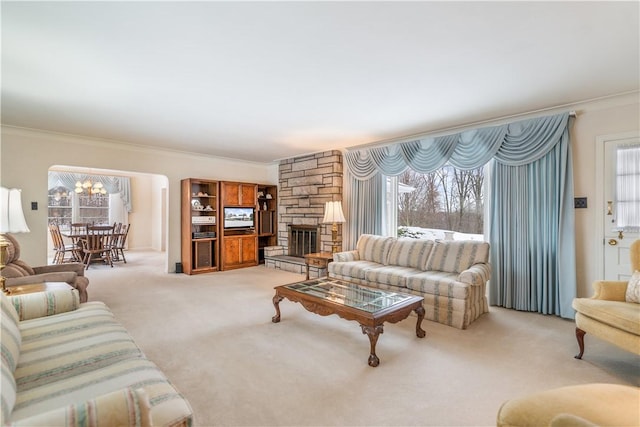 carpeted living room featuring ornamental molding and a stone fireplace