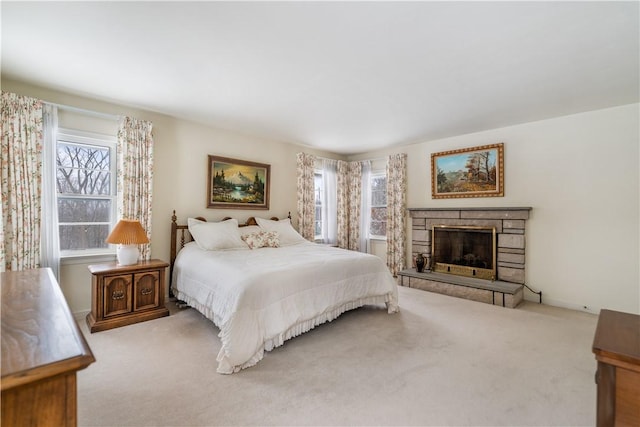 bedroom featuring a fireplace and light carpet