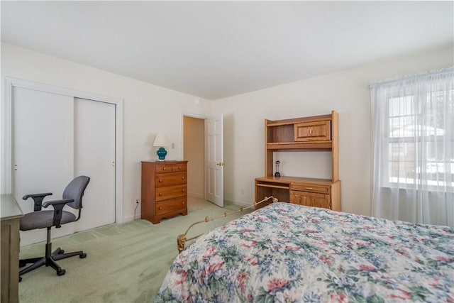 bedroom with light colored carpet and a closet