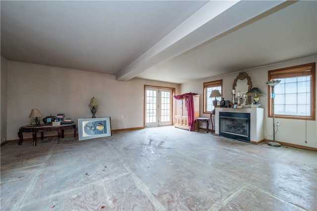 unfurnished living room with beam ceiling and french doors