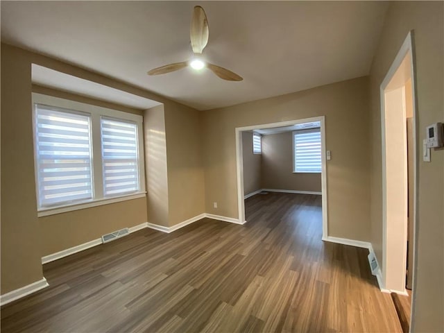 spare room with dark hardwood / wood-style flooring and ceiling fan