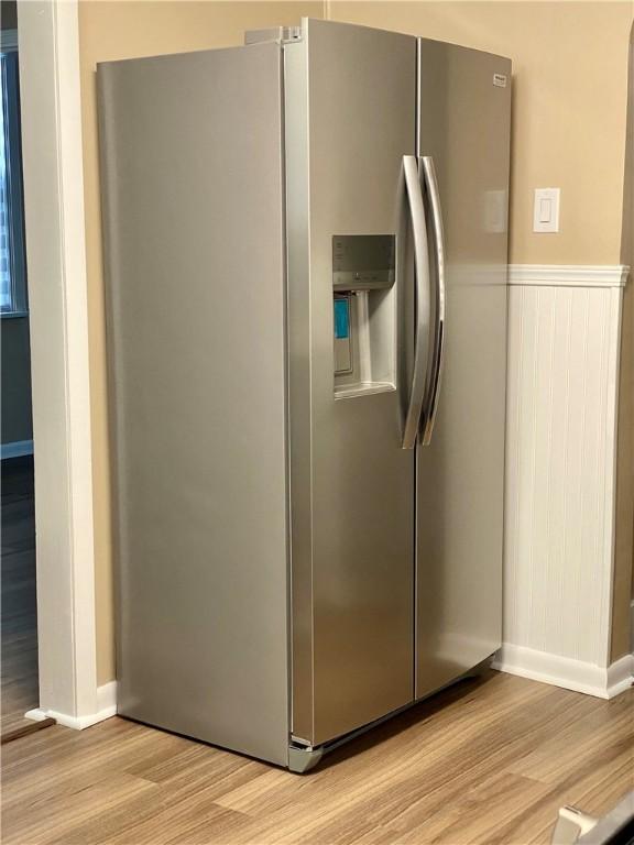 kitchen with stainless steel refrigerator with ice dispenser and light hardwood / wood-style floors