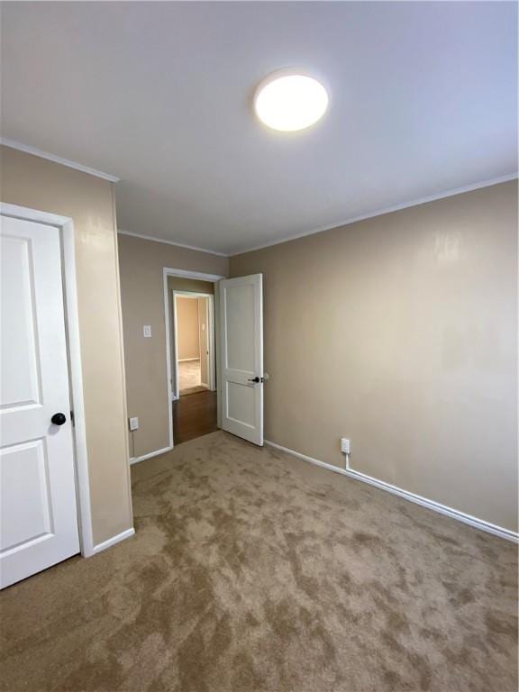 unfurnished bedroom featuring ornamental molding and carpet flooring