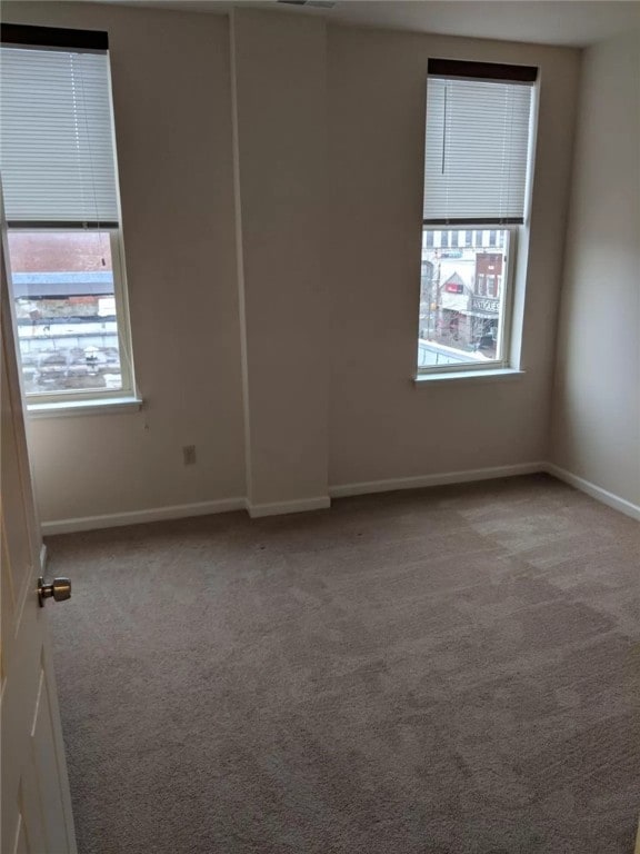 carpeted empty room featuring a healthy amount of sunlight