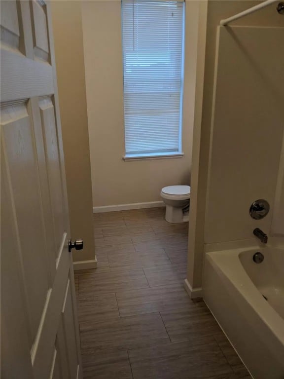 bathroom with shower / washtub combination and toilet