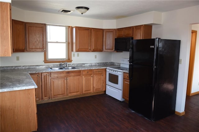 kitchen featuring brown cabinets, visible vents, a sink, and black appliances