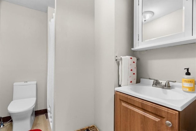 bathroom featuring vanity, hardwood / wood-style floors, and toilet