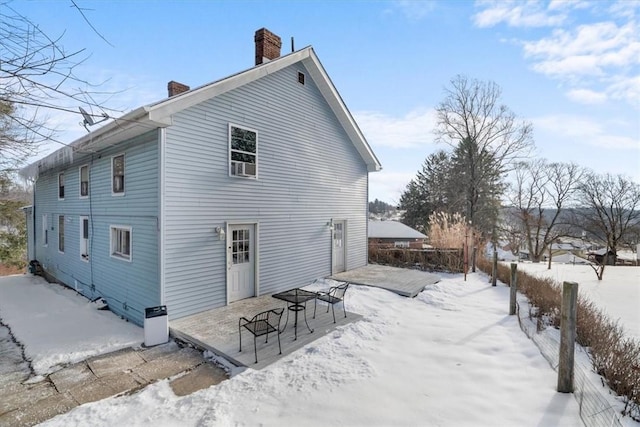 view of snow covered back of property