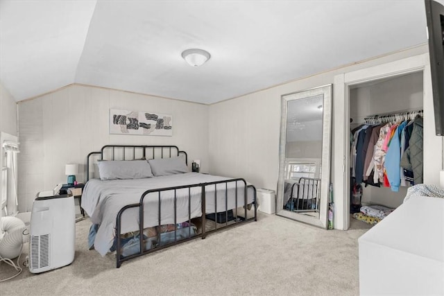 bedroom with light colored carpet, vaulted ceiling, and a closet