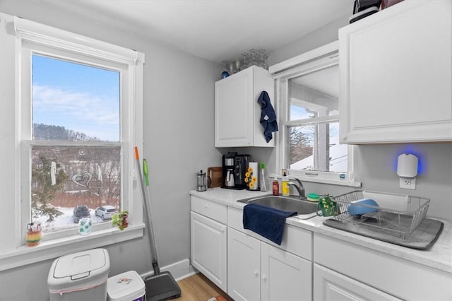 kitchen featuring white cabinetry, sink, and light hardwood / wood-style flooring