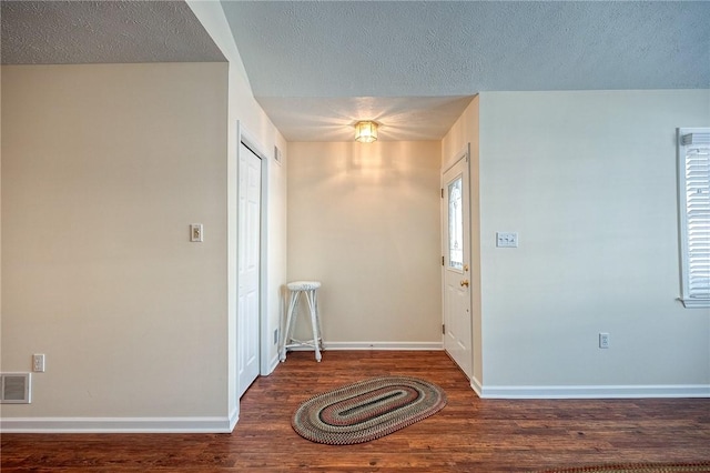 foyer with dark hardwood / wood-style flooring and a textured ceiling