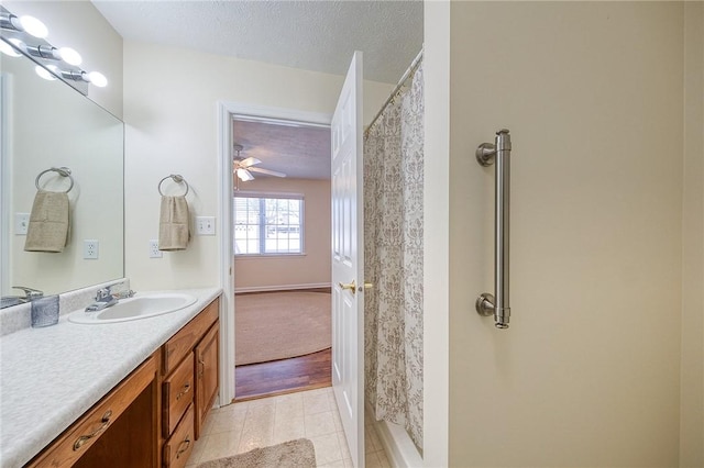 bathroom with vanity, ceiling fan, and a textured ceiling