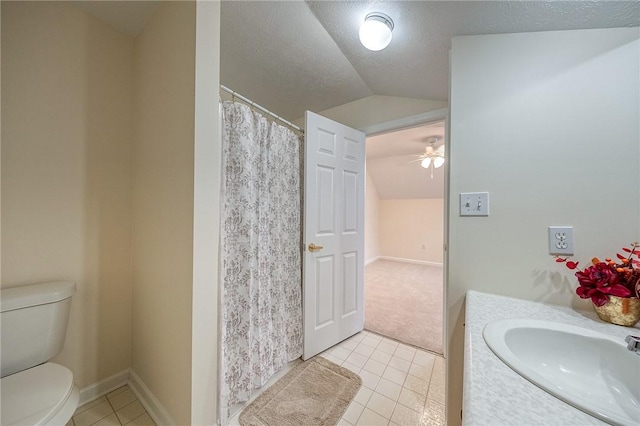 bathroom featuring toilet, sink, vaulted ceiling, a textured ceiling, and tile patterned flooring