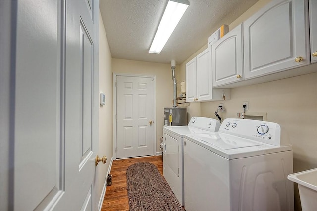 laundry room featuring sink, washing machine and dryer, cabinets, a textured ceiling, and dark hardwood / wood-style flooring