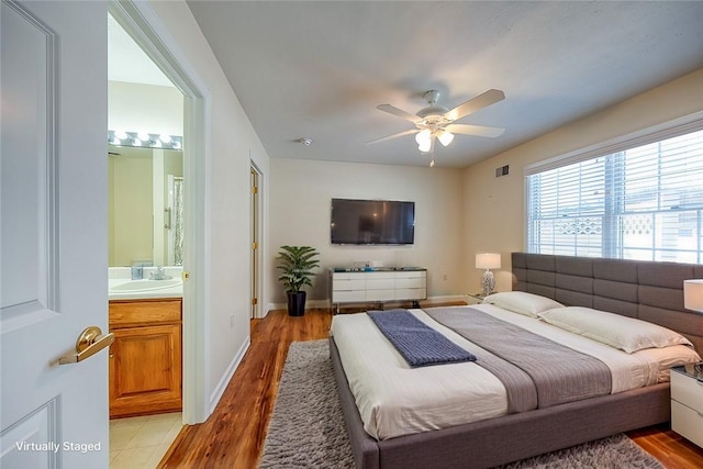 bedroom featuring ensuite bathroom, sink, ceiling fan, and light hardwood / wood-style flooring