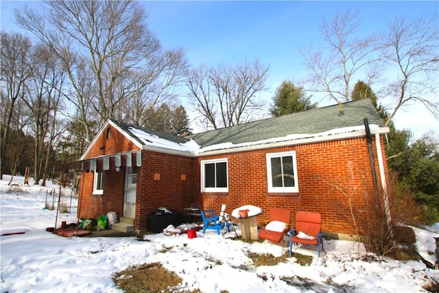 view of snow covered back of property