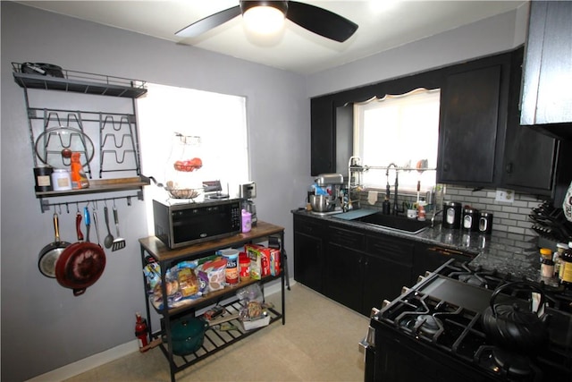 kitchen featuring ceiling fan, sink, backsplash, and range with gas cooktop