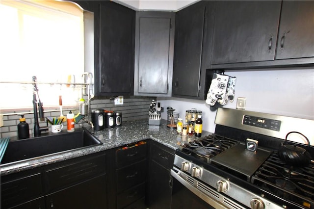 kitchen featuring dark stone countertops, sink, and gas stove