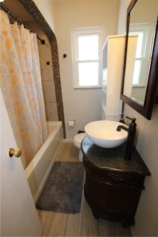 full bathroom featuring vanity, hardwood / wood-style floors, shower / tub combo, and toilet