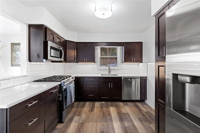 kitchen featuring sink, decorative backsplash, dark wood-type flooring, and stainless steel appliances