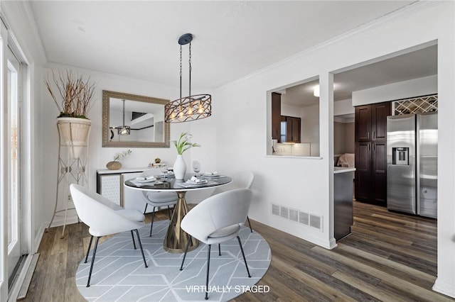 dining space featuring crown molding and dark hardwood / wood-style flooring