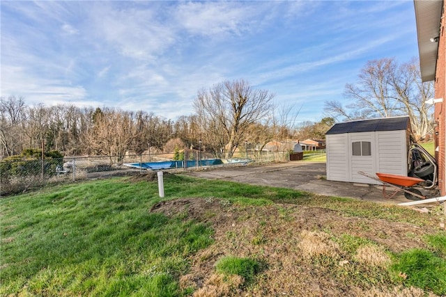 view of yard with a storage shed, a covered pool, and a patio