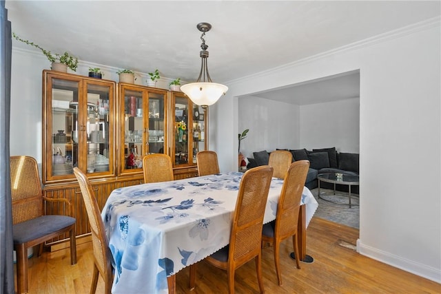 dining area featuring ornamental molding and wood-type flooring