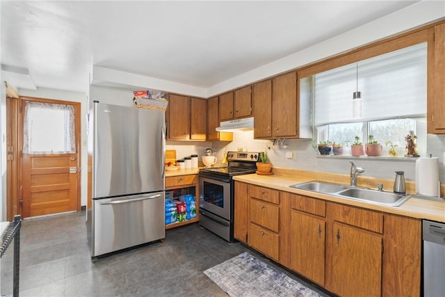 kitchen featuring stainless steel appliances, plenty of natural light, sink, and pendant lighting