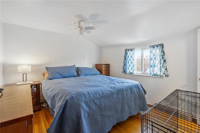 bedroom with hardwood / wood-style flooring, vaulted ceiling, and ceiling fan