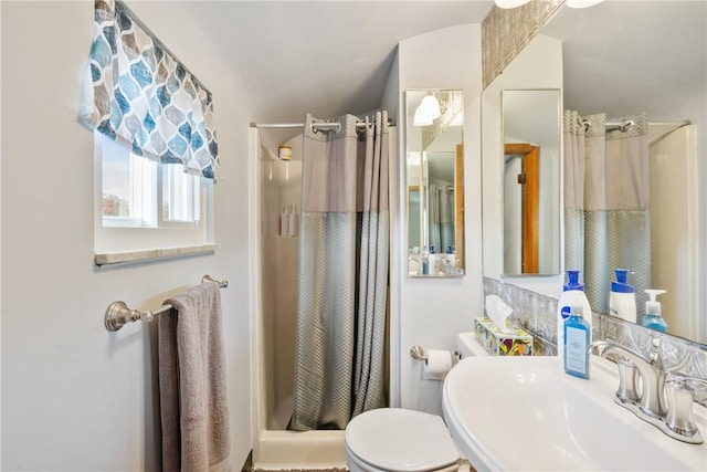 bathroom featuring walk in shower, toilet, and sink