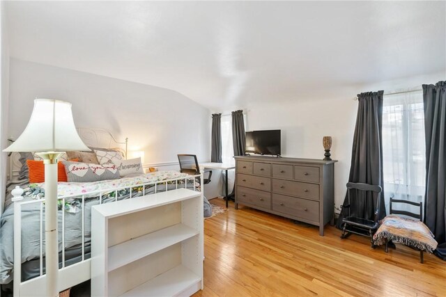 bedroom with lofted ceiling and light hardwood / wood-style floors