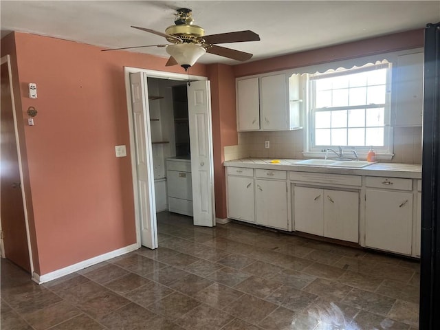 kitchen featuring sink, white cabinets, ceiling fan, and decorative backsplash