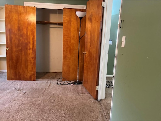 unfurnished bedroom featuring light carpet and a closet